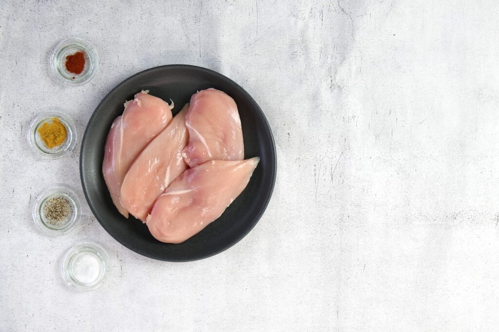 two raw chicken breasts in a black bowl