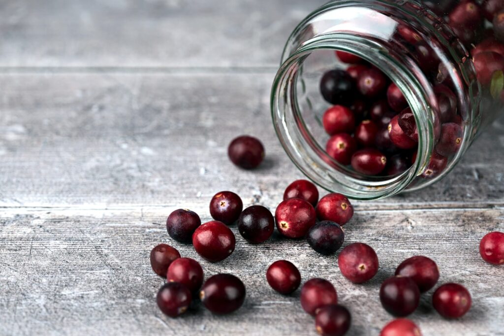 Jar and cranberries. Selective focus on cranberries and jar sides. Close up
